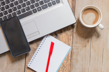 work office desk with a cup of coffee computer laptop, notebook, pen
