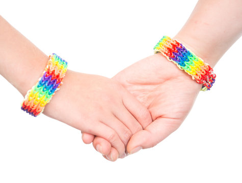 Young woman's hands with a bracelet patterned as the rainbow fla