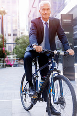 Obraz premium Successful businessman riding bicycle