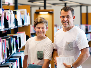 Obraz premium Boy and his father in library
