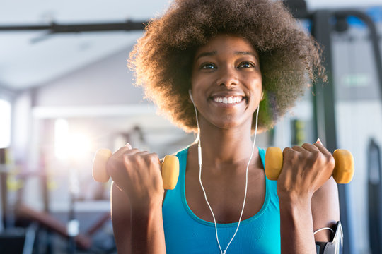 Happy healthy young African American woman working out in a gym