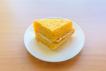 Orange vanilla cake on wooden table