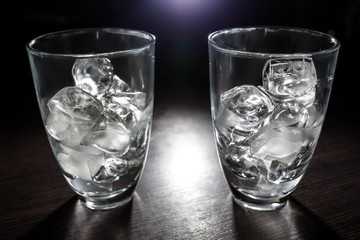 two empty glasses with ice cubes;
