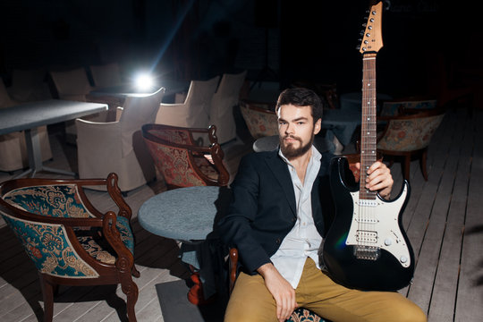 stylish bearded man with electric guitar;