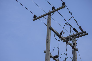 High voltage electricity pole with blue clear sky background