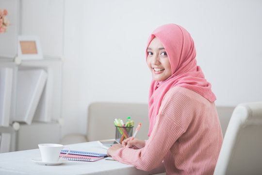 female student wearing hijab smiling to camera