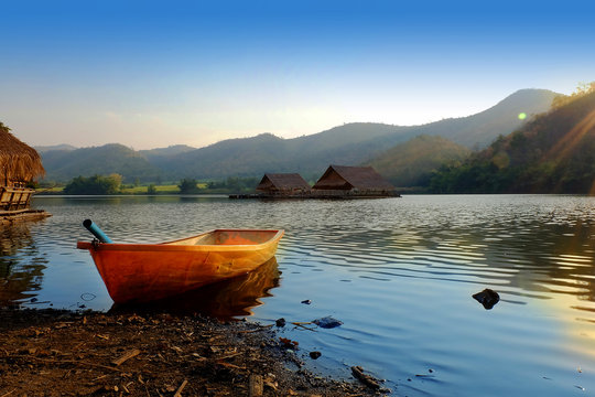 boat in  the lagoon with mountain background at khao wong reservoir Suphanburi province Thailand with sunset light in the evening 