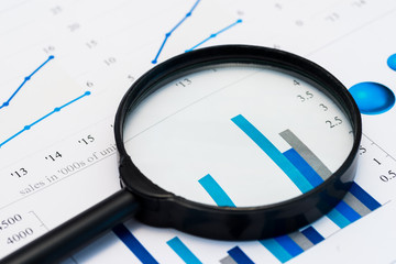 Business Analysis Image - magnifying glass on graphs and spreadsheet - obrazy, fototapety, plakaty