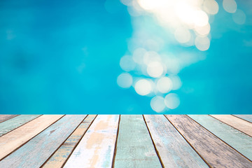 Wood table top and blurry blue water bokeh abstract background