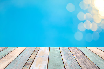 Wood table top and blurry blue water bokeh abstract background