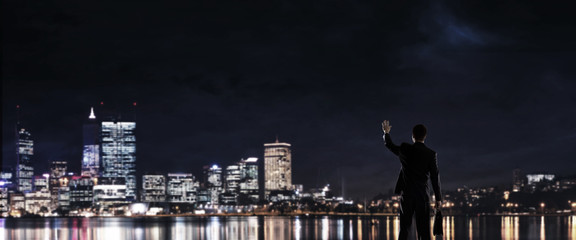 Fototapeta na wymiar Businessman viewing night glowing city