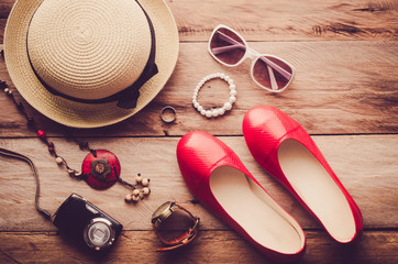 Hats, shoes and accessories to dress lay on the wooden floor for travel - Vintage tone.