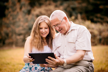 Grandchild shows grandfather tablet