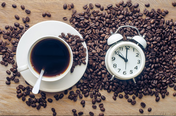 Coffee and coffee beans are placed near the alarm clock - concept articles useful as well