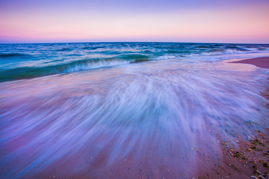 Waves motion during golden hour sunset over the sea.