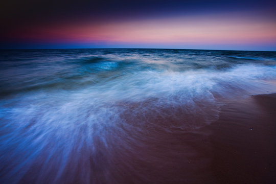 Waves motion during golden hour sunset over the sea.