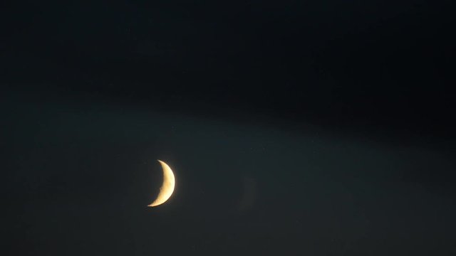 Young moon.Black clouds on the moon. Astro photography.