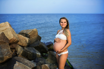 Fototapeta na wymiar Pregnant woman on the sandy beach