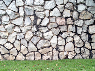 large grey stone wall and backyard green grass lawn, yard relaxing corner