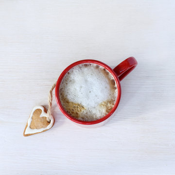 favorite warming drink/ flat layout with a frothy cappuccino and ginger cookies in the shape of heart