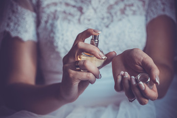 bride applying perfume on her wrist