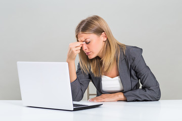 Beautiful businesswoman is having headache while she is working.
