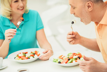 Obraz na płótnie Canvas Senior married couple eating salad in restaurant