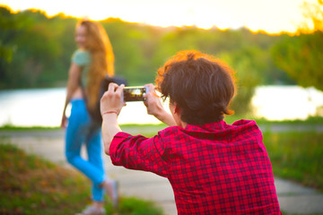 Boyfriend takes pictures of his girlfriend outdoors