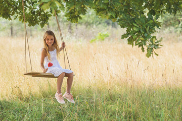Pretty girl swinging on meadow