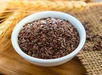 flaxseeds in white bowl on wood table