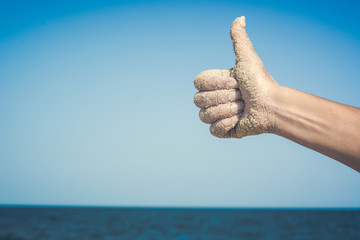 Woman's hand against blue sea