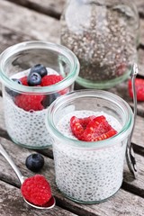 Overnight chia seeds pudding with fresh raspberries in glass jar. Healthy breakfast to go. Superfoods concept 
