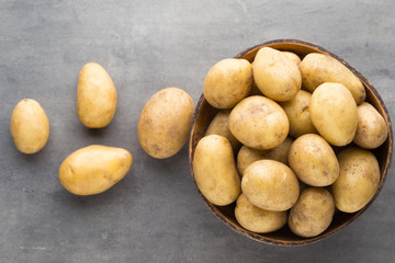 New potato on the bowl, gray background.