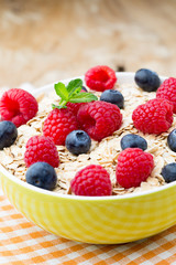 Oatmeal porridge with berries. Raspberries and blueberries.