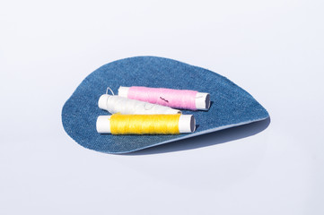 Spool of thread with needles and clippers on white background