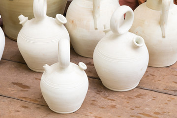 white clay jugs of freshly made on a wooden table
