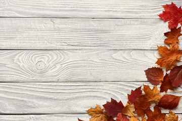 Naklejka na ściany i meble Wooden background with autumn leaves