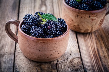 juicy fresh organic blackberries in mugs