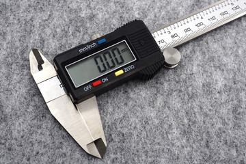digital vernier caliper (measurement tool) on grey background.
