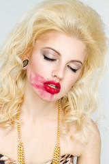 Beautiful young woman with makeup smearing lipstick. Glamour style. Sensual Posing