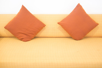 Sofa with orange pillows in room