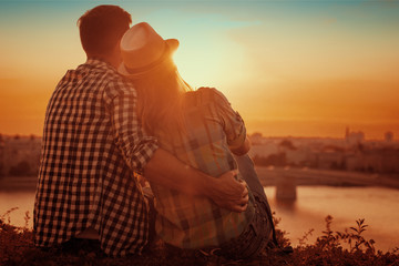 Young couple enjoying the sunset - obrazy, fototapety, plakaty