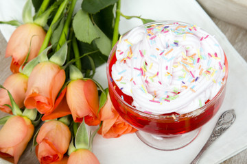 Colorful jelly with whipped cream and candy topping