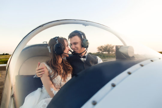 Happy young couple in headphones smiling in the cockpit. Travel concept