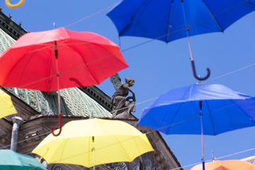 Colorful umbrellas on background of sculptures on the roof