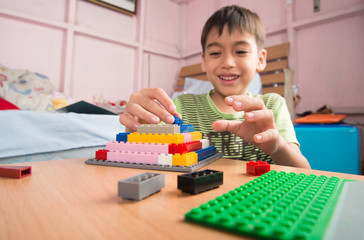 Little boy playing plastic block building indoor activity education