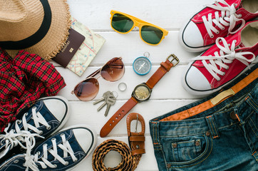 Clothing for travel, placed on a white wooden floor.