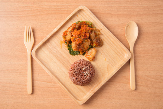 Brown rice with spicy paste stir fried with fish  in wooden dish