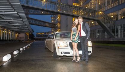Fototapeta na wymiar Cute couple in front of a limousine
