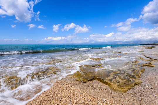 Waves breaking on beach coast near Acharawi village, Corfu, Greece.